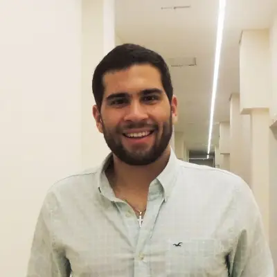 Retrato de Juan Manuel Duarte, fundador de Stanford.uy, sonriendo en un pasillo iluminado.