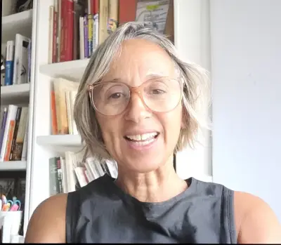 Virginia de Vir Arlington sonriendo en su oficina con estanterías llenas de libros al fondo